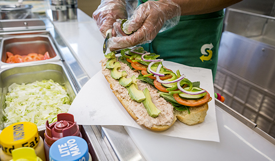 Sub sandwich being prepared