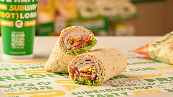 Subway's Turkey, Bacon and Avocado wrap on Subway sandwich paper with chips and drink